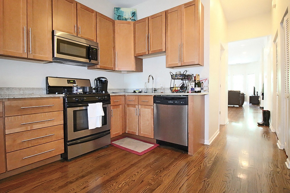 a kitchen with wooden cabinets and stainless steel appliances